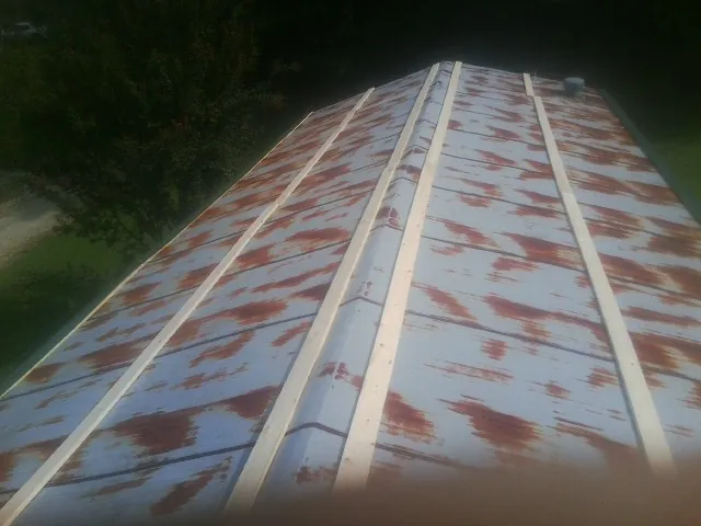 Rusted metal roof panels with new wood purlins before replacement — Storm Damage Roof Repair in Murphy by Roofing Brothers