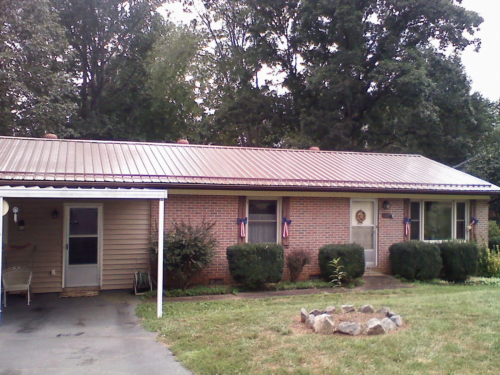 Bronze metal roof and carport on a brick ranch home — Roof Repair work by our crew in Murphy