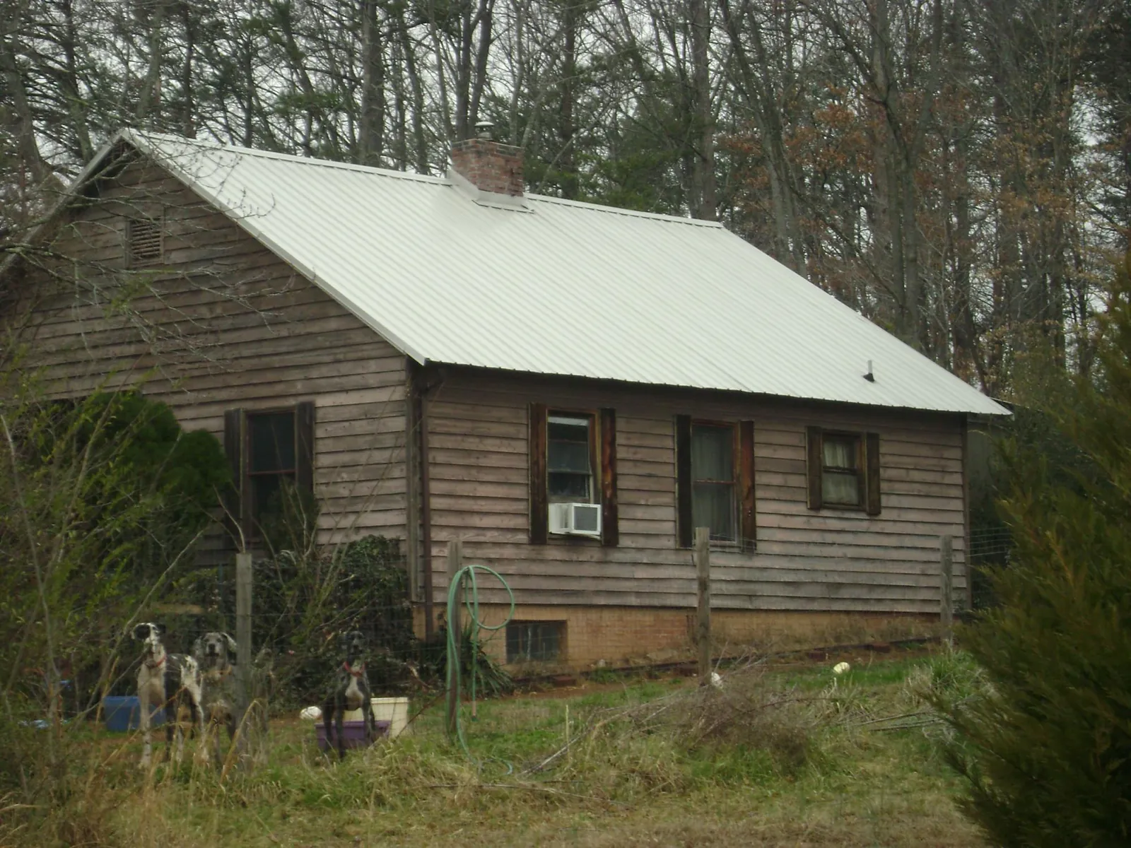 White metal roof on an old wood sided farmhouse, from a Metal Roof Installation job in Murphy
